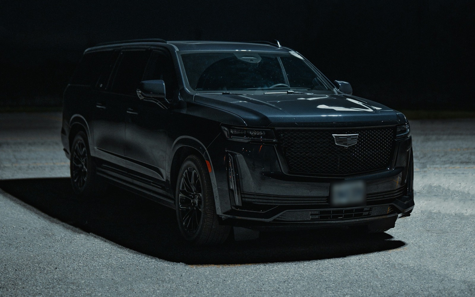 Black full-size luxury SUV parked at night